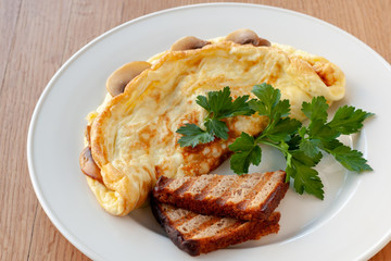 Omelet with mushrooms, decorated with herbs and toast.