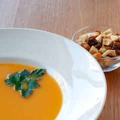 Pumpkin curry soup decorated with herbs and croutons.