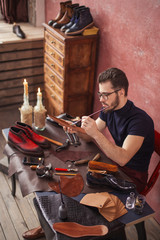 attractive guy in glasses smears special liquid with a brush . side view photo