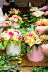 women's hands make bouquets of flowers in boxes, a master class or work in a flower shop