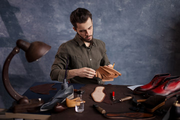 young bearded cobber holding a set of cloth for footwear . close up photo. lifestyle