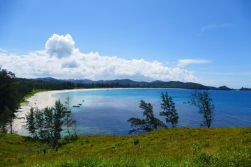 photo picture of a beautiful sea and ocean view with a natural background of rocks, forests and mountains
