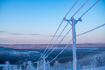 Frost and snow covered power lines during very cold winter against sky in Finland - Powered by Adobe