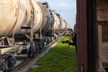 wagons transporting fuel or other industrial goods passing by abandoned wagons and a photographer...
