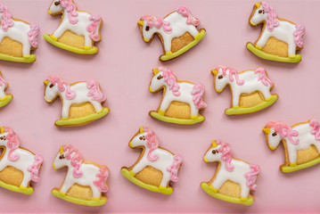 Unicorn shaped sugar cookies decorated with pastel royal icing on pink background