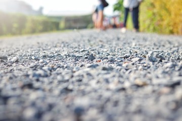 gray granite gravel walking way with many people is walking