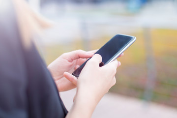 Executive working with a mobile phone in the street with office buildings in the background