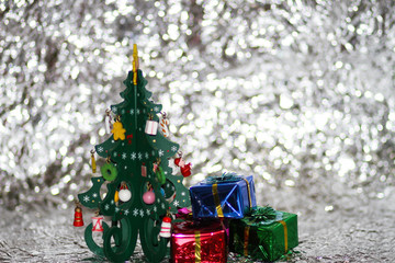 Close-up green wooden Christ mas tree with decorations on blur light and bogey background.