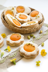 Cookies in the shape of white eggs with apricot yolk with pistachios as homemade decoration