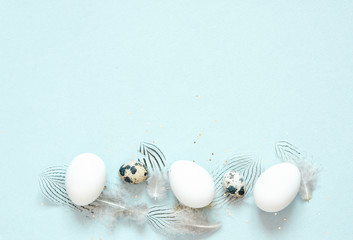 Easter composition with easter eggs and feathering on blue background, space for text - Image