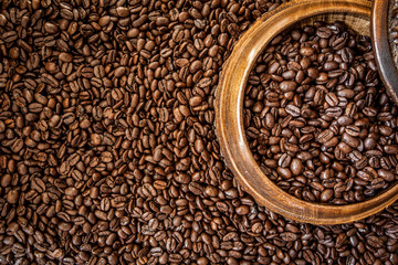 Fresh roasted arabica and robusta coffee beans. Coffee in a wooden bowl