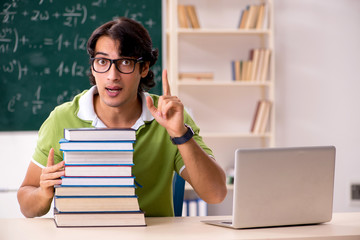 Handsome student in front of chalkboard with formulas 