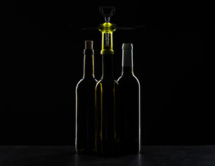 Bottle of wine with corkscrew on the black stone background