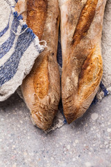 Two wheat Sourdough Baguettes on a linen napkin. Detail of two homemade artisanal bread.