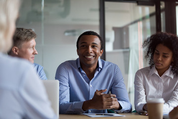 Diverse businesswomen and businessmen communicating while sitting in conference 
