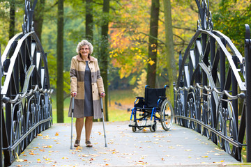older woman practicing walking on crutches