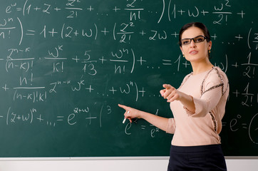Female teacher standing in front of chalkboard   