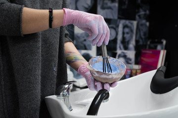 Professional hairdresser drying woman's hair with hairdryer in beauty salon