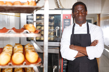 Confident baker near professional bread oven