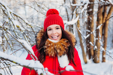 Portrait of young beautiful woman in red clothes on winter outdoor background