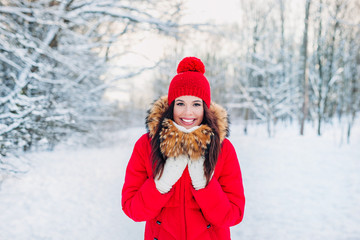 Fototapeta premium Portrait of young beautiful woman in red clothes on winter outdoor background