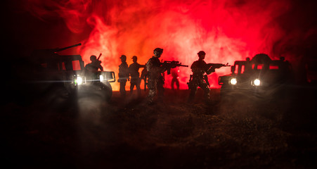 Fototapeta premium War Concept. Military silhouettes fighting scene on war fog sky background, Fighting silhouettes Below Cloudy Skyline At night. Battle scene. Army vehicle with soldiers. army