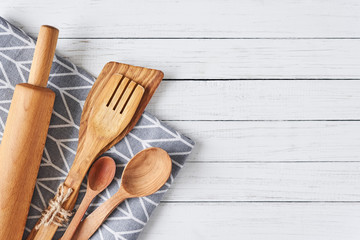 Kitchen utensils, rolling pin, spatula and towel on a white wooden background with copy space