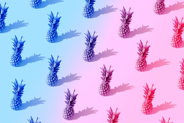 Neon pineapple fruits pattern on pink and blue background. Summer concept