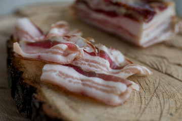 Delicious artisanal whole smoked slab bacon on a cutting block