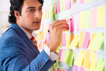 Young handsome employee with many conflicting priorities 