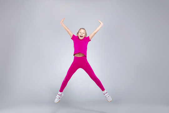 Young caucasian girl doing gym exercises in sportwear
