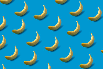 Obraz na płótnie Canvas Pattern of yellow bananas on blue background.