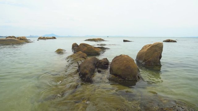 wave on clear water sea beach with rock or stone and mountain on holiday relax and vacation travel at bang saen in Thailand with nature sound on 4K