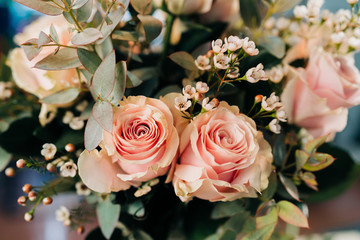 Pink Roses bouquet in a vase on a wooden table. Florist