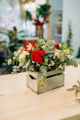 Flowers bouquet in wooden box on a table. Florist