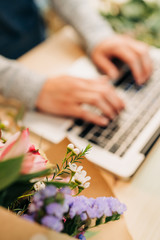 Woman florist using laptop at her flower shop. Business