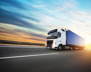 Fototapeta na wymiar Loaded European truck on motorway in sunset