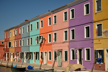 Fototapeta na wymiar Colorful concept, orange, pink, purple. Venice, Burano island canal, small colored houses and the boats