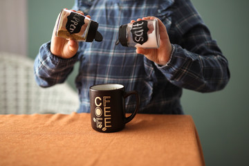 Joke child pours salt and pepper in coffee