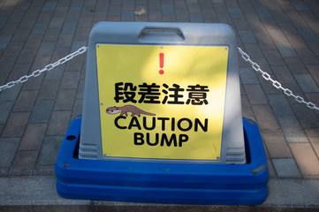 A blue-colored mini barricade with a yellow-colored sign which says 