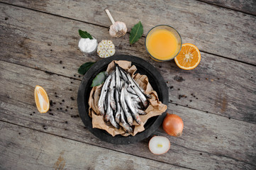 Fresh anchovies on plate with on a baking paper with a food around