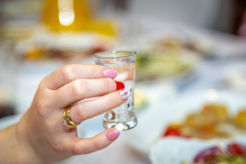 women toasting, a glass of vodka, a woman's hand