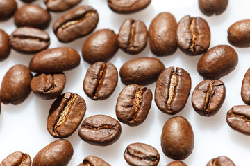 Roasted coffee beans on white can be used as background or texture. Close up.