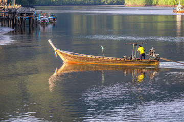 The background of a small fishing boat that is about to dock and there is a blur of water flowing through, being a coexistence of people and nature.