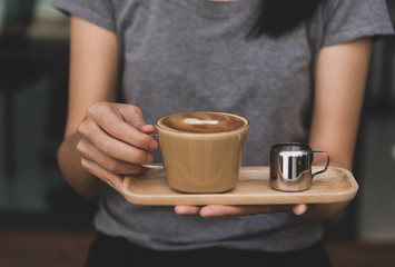 Close-up shots of the woman hand holding a coffee mug and serving to the customer.