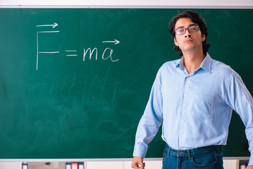 Young male physic standing in front of the green board