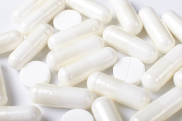 White pills on white background. Texture.