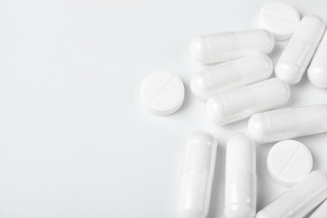 White pills on white background with copy space.
