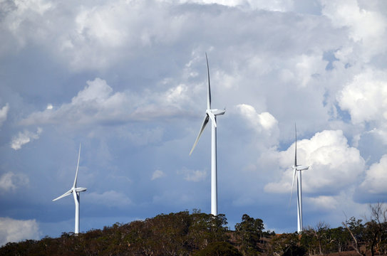 Wind turbines under a dramatic cloudy sky between Goulburn and Yass in rural New South Wales, Australia.