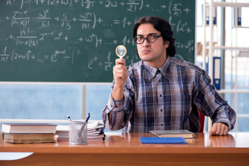 Young funny math teacher in front of chalkboard 